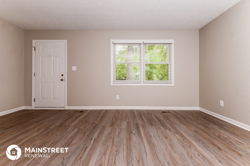 the interior of an empty room with wooden floors and a white door