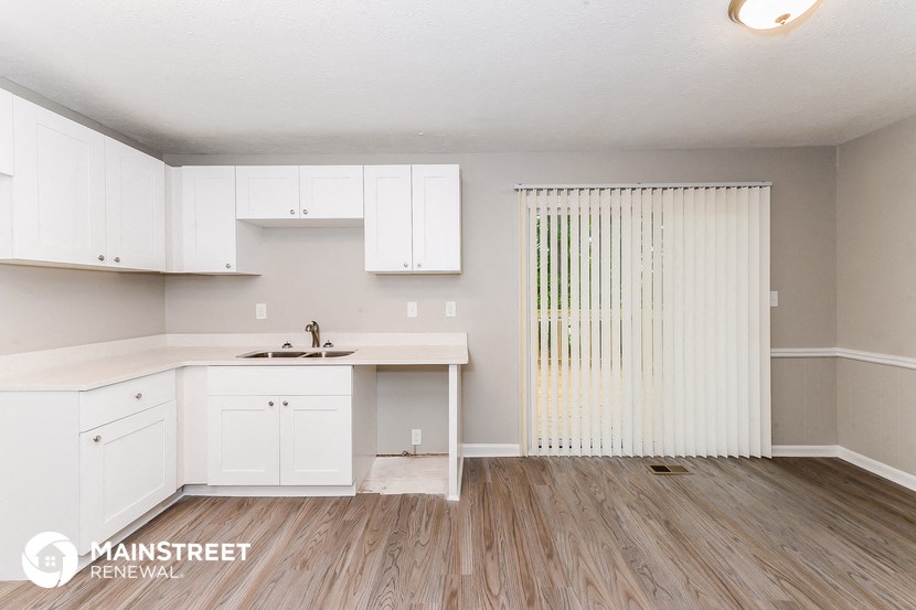 a kitchen with white cabinets and a sink and a counter