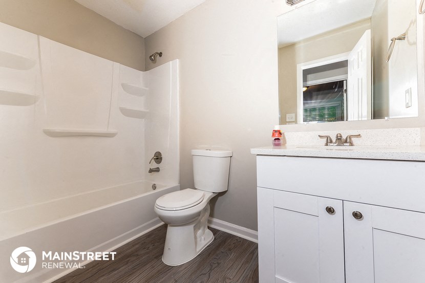 a bathroom with a toilet and a bath tub and a sink
