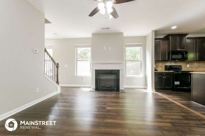 the living room of a new home with wood flooring and a fireplace