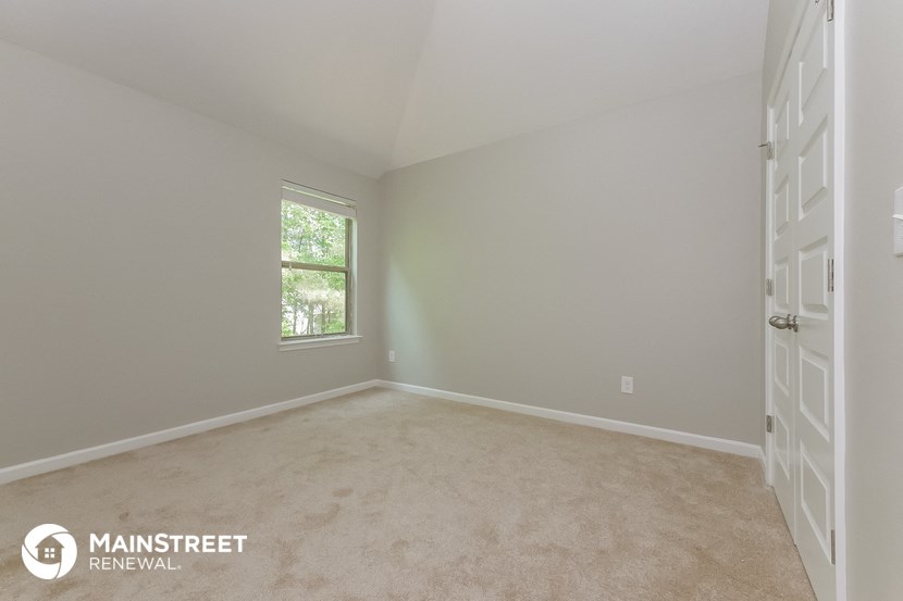 a bedroom with a carpeted floor and a window