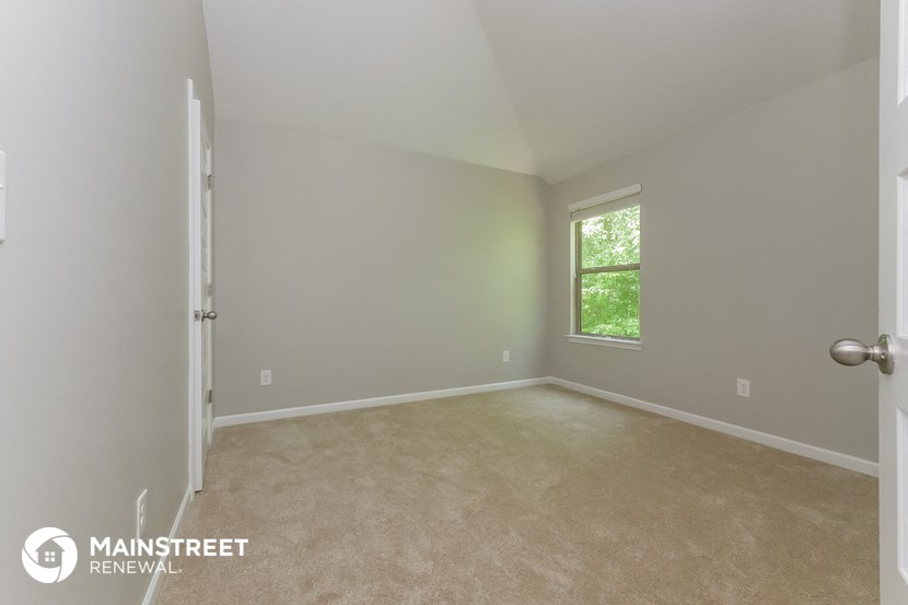 a bedroom with a carpeted floor and a window