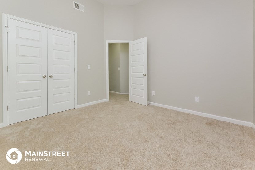 a bedroom with two closets and a carpeted floor