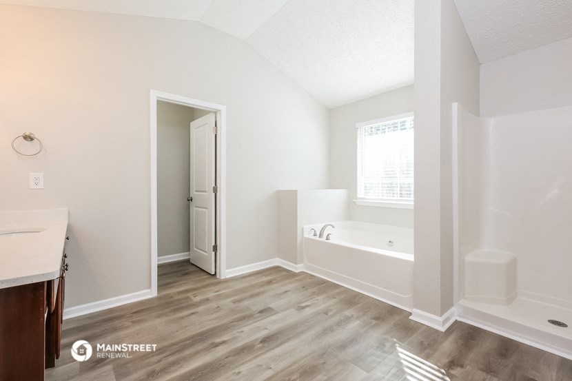 a white bathroom with a tub and a sink