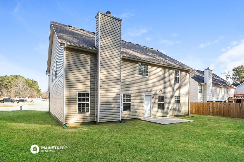 an old farm house with a garage and a shed on the side