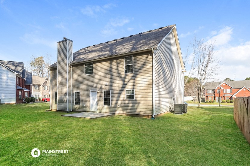 a small house in a backyard with a yard and a fence