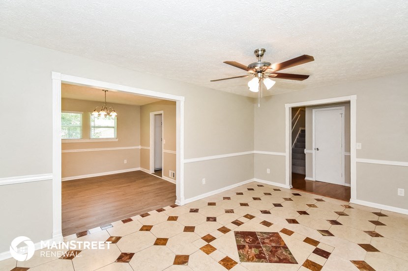 an empty living room with a ceiling fan
