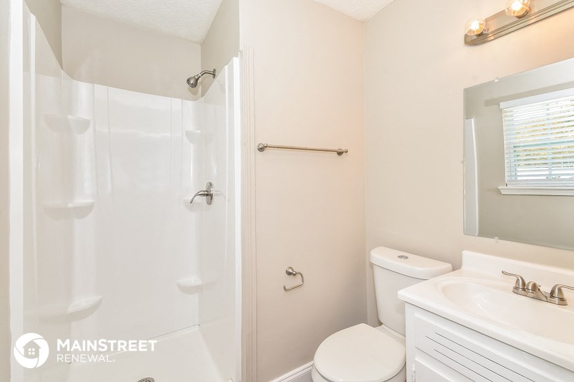 a bathroom with a shower and a sink and a toilet