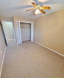 an empty room with a ceiling fan and a closet
