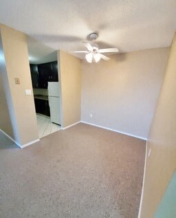 an empty living room with a ceiling fan