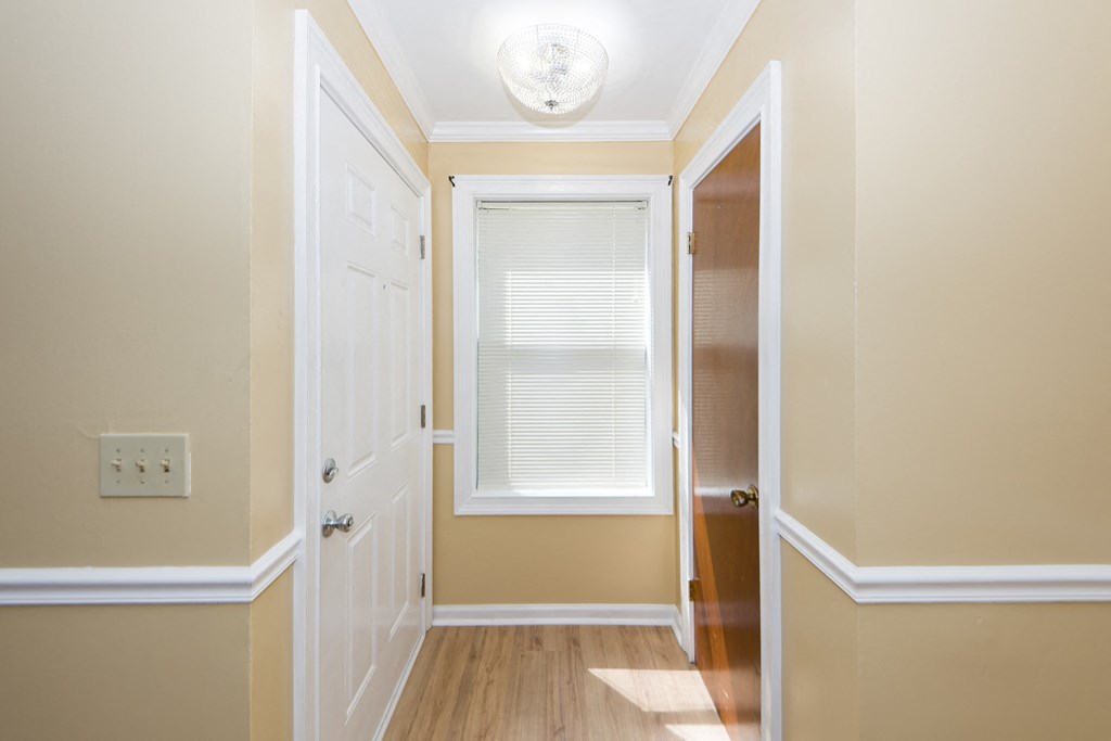 a hallway with a door to a closet and a window
