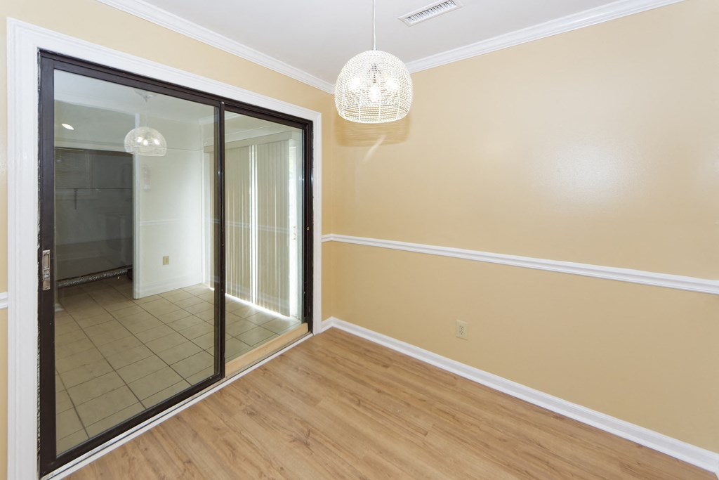 an empty room with a mirror and a door to a hallway