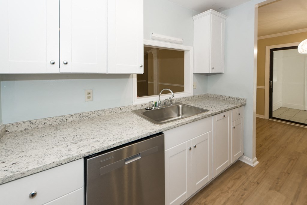 a kitchen with white cabinets and a stainless steel sink