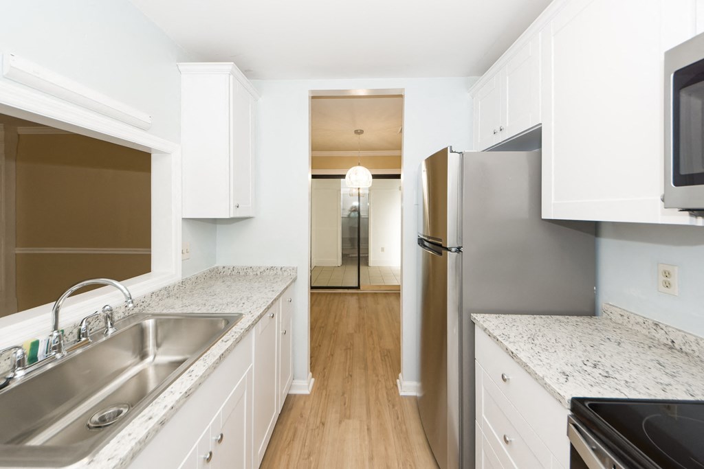 a kitchen with white cabinets and a stainless steel refrigerator