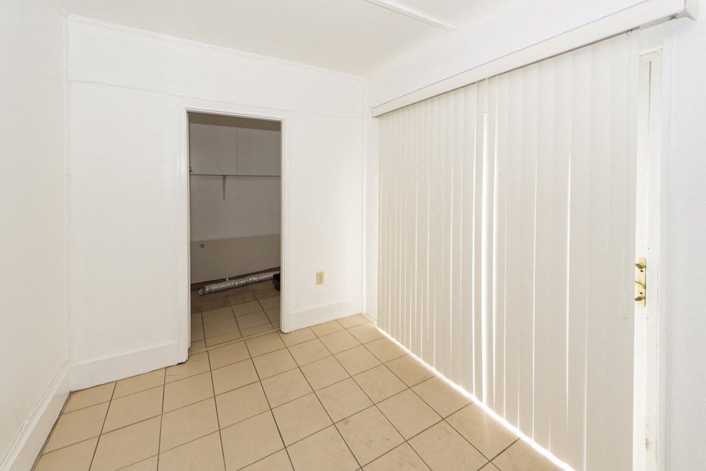 an empty room with white doors and a tiled floor