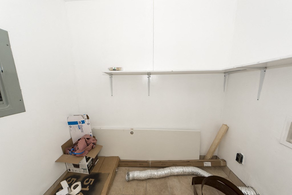 a room with a white wall and boxes on the floor