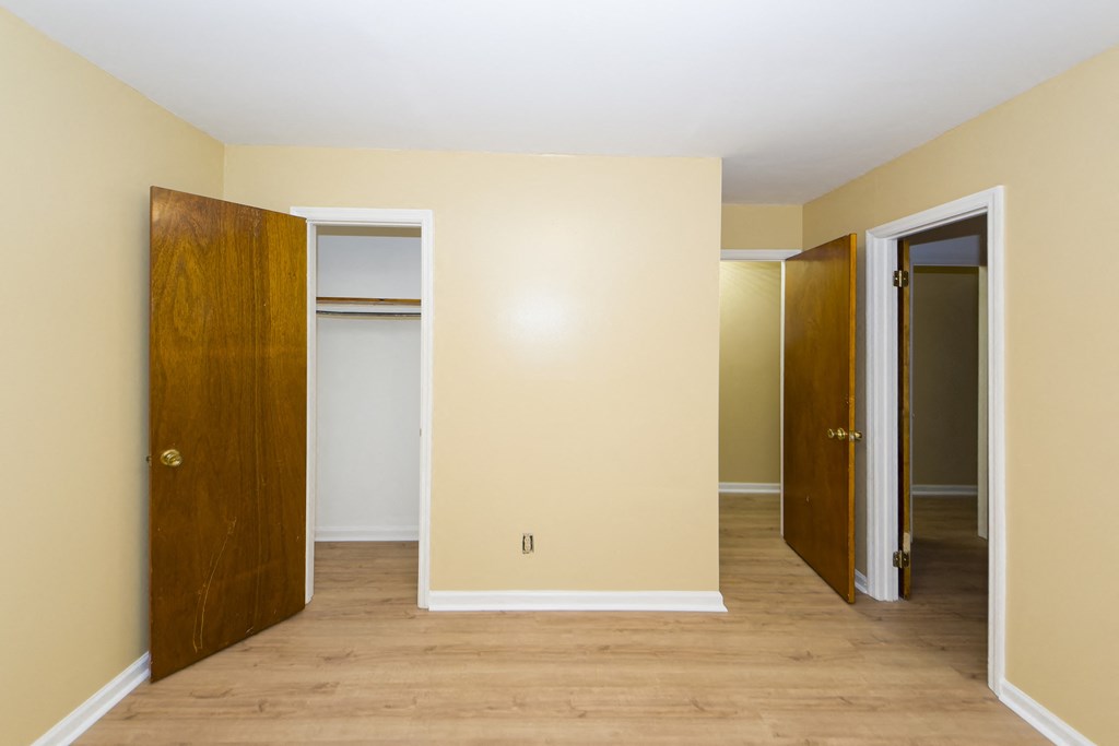 a empty room with doors and a door to a closet