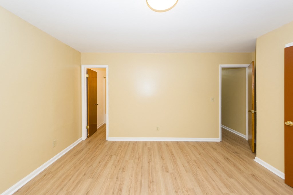 a empty room with a hard wood floor and tan walls