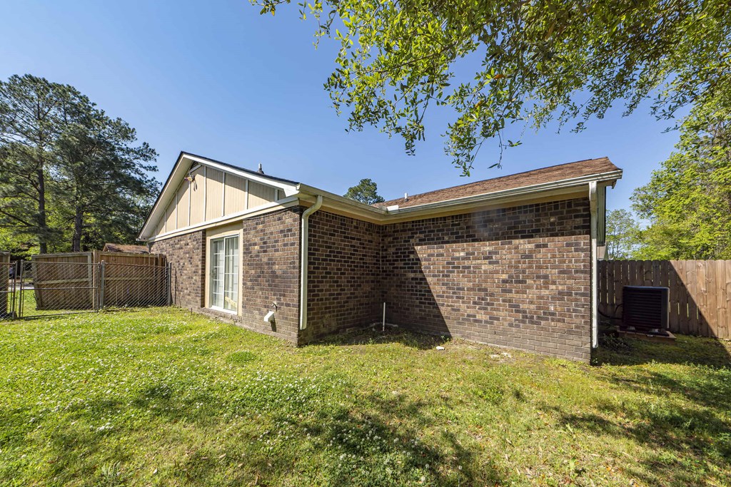 a brick house with a yard and a fence