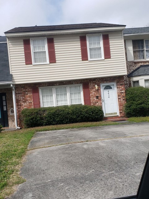 A house with a red brick wall and a white door.