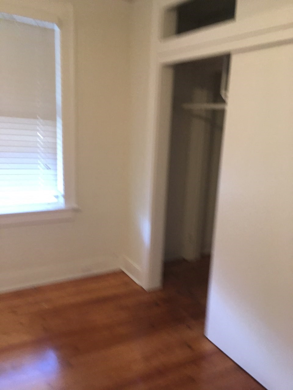 A white refrigerator in a room with wooden floors.