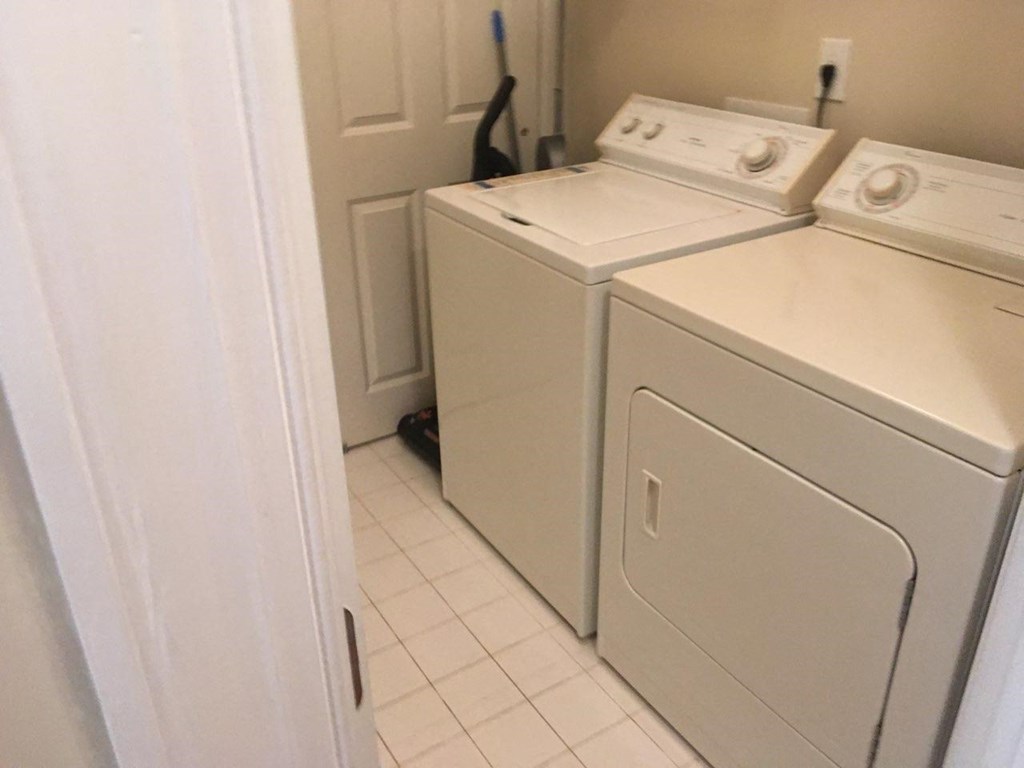 A white washing machine and dryer in a small laundry room.
