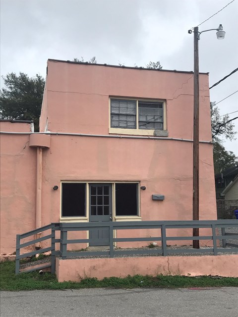 A pink building with a grey door and window.
