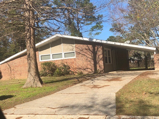 a brick house with a sidewalk and a tree