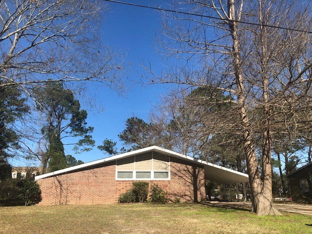 a brick house with trees in front of it
