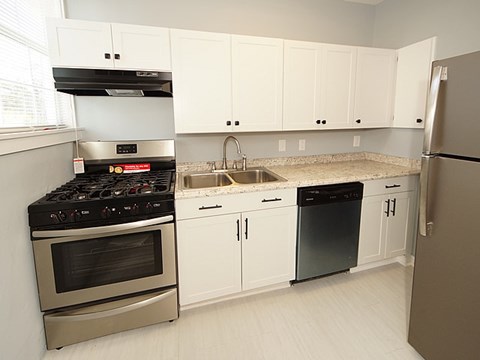 A kitchen with white cabinets and a black stove top oven.