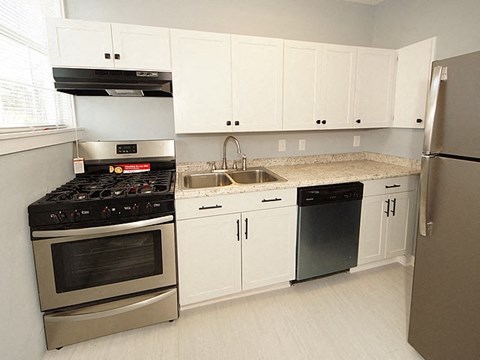 A kitchen with white cabinets and a black stove top oven.
