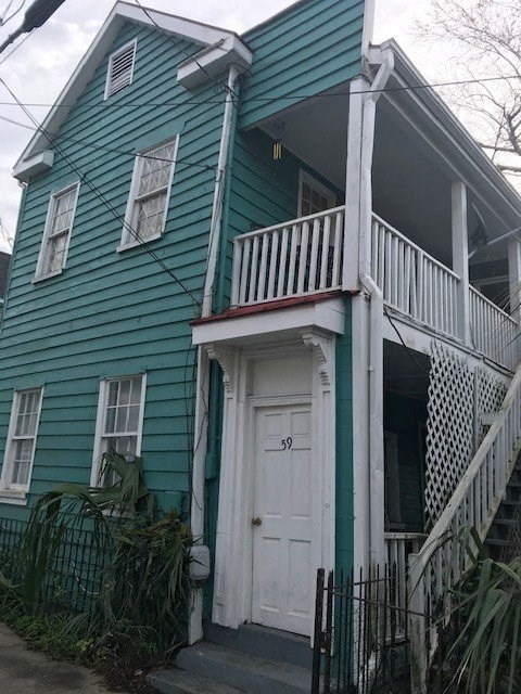 a green house with a porch and a white door