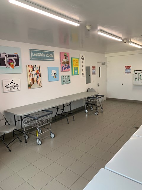 a meeting room with desks and chairs and paintings on the wall