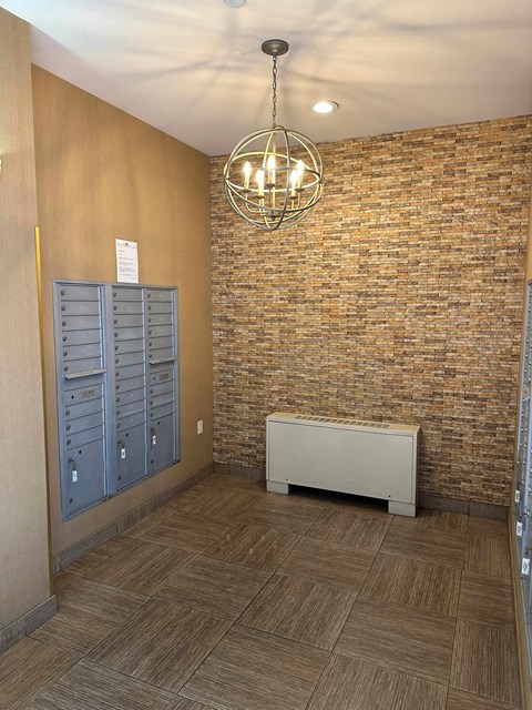 a hallway with a brick wall and lockers and a chandelier