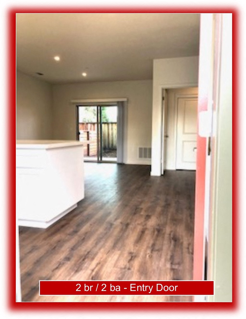 a view of a living room and kitchen from the entry door