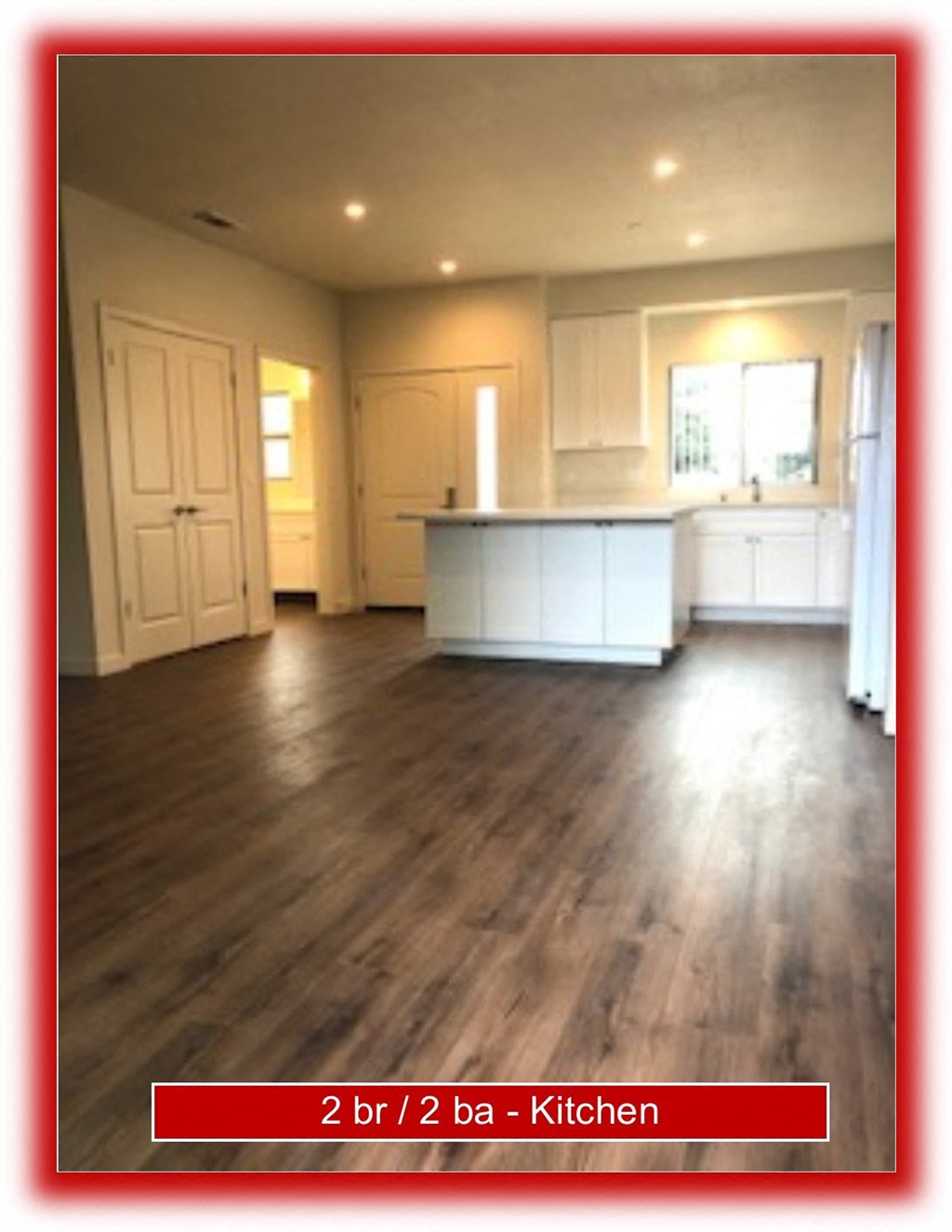 an empty kitchen and living room with wood floors