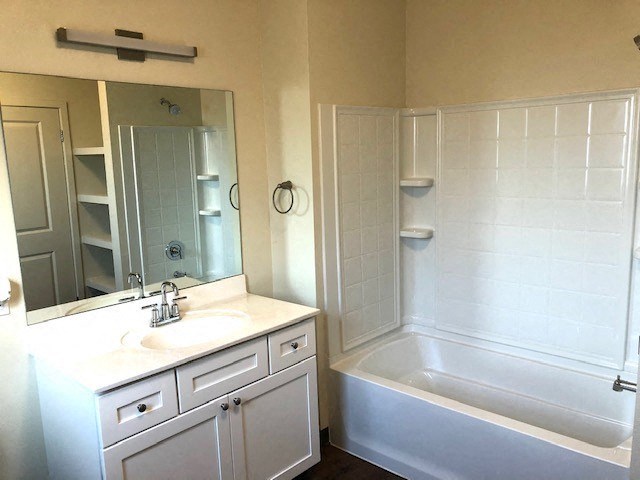 a bathroom with a sink and a tub and a mirror