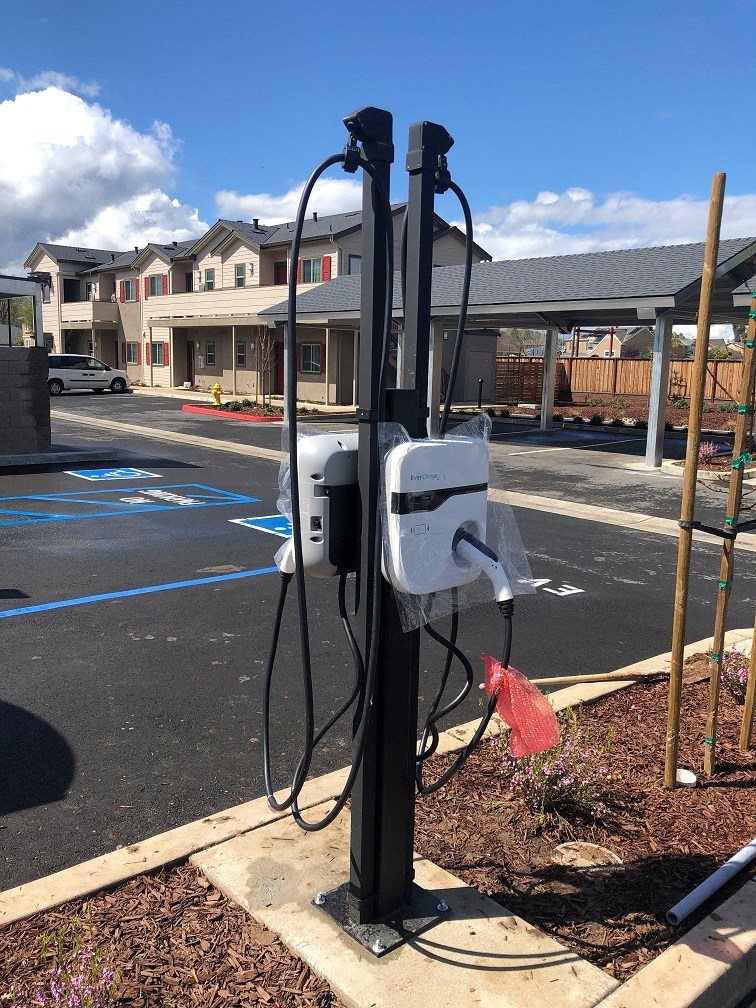 an electric pole with a power meter on the side of a street