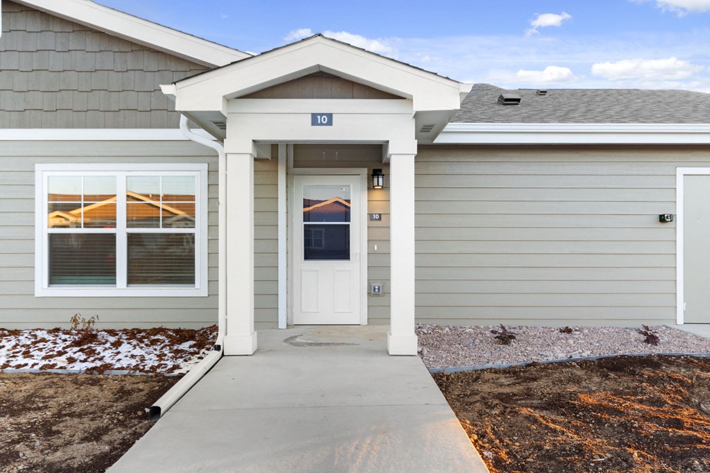 the front of a home with a porch and a white door