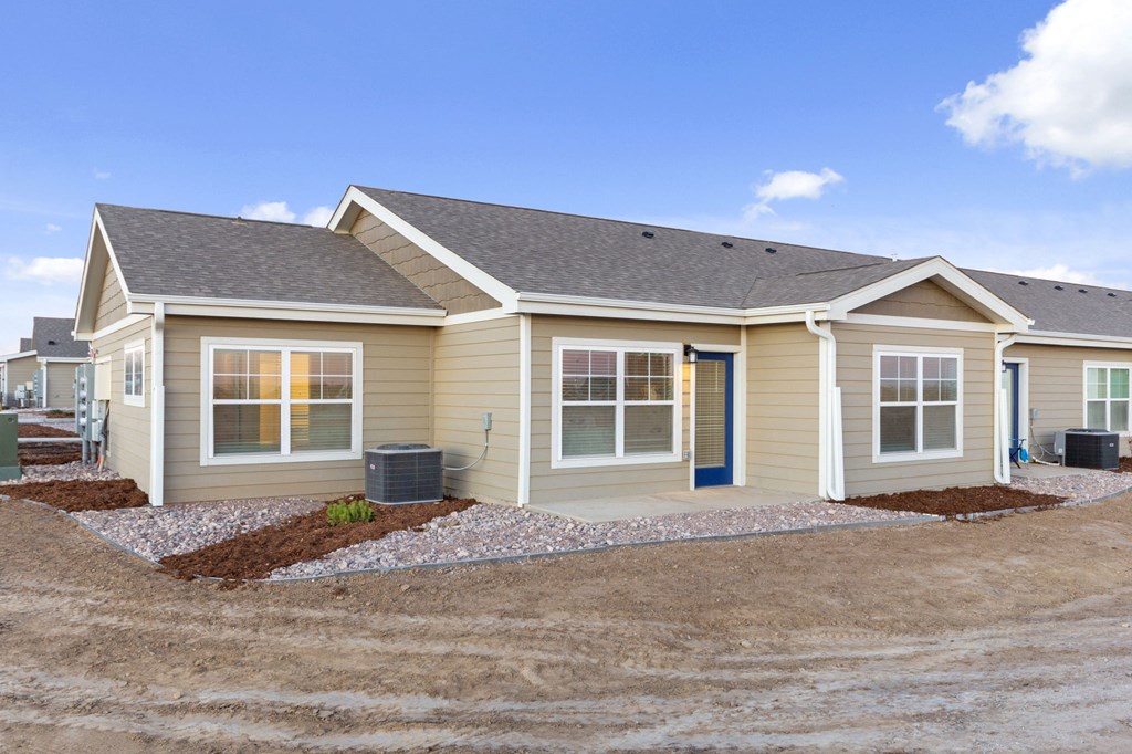 a beige house with a yard and a driveway