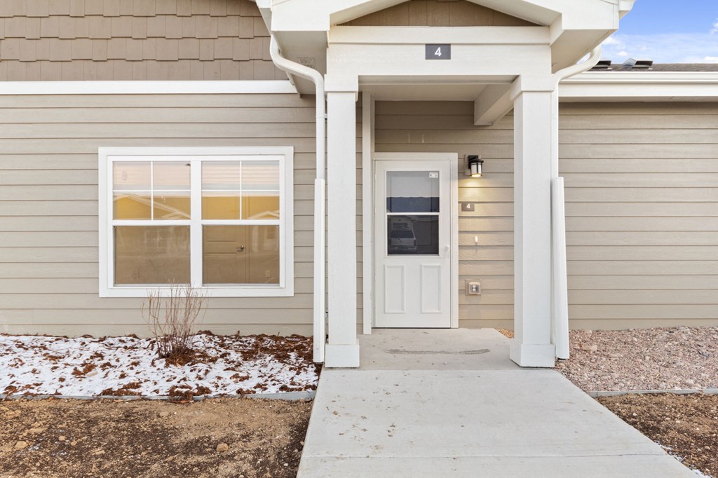 the front of a home with a white door and a sidewalk