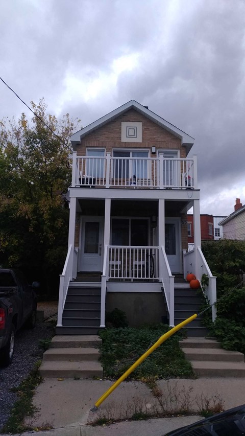 the front of a house with a yellow hose in front of it