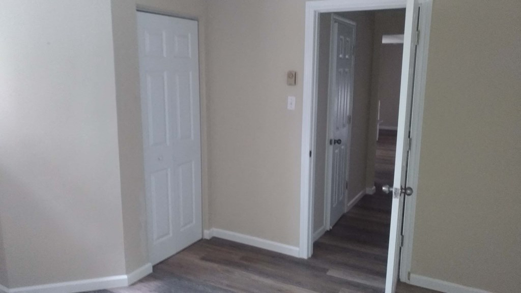 a room with a door open to a hallway and a closet