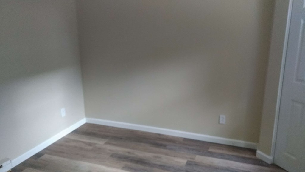 a empty room with wooden floors and white walls