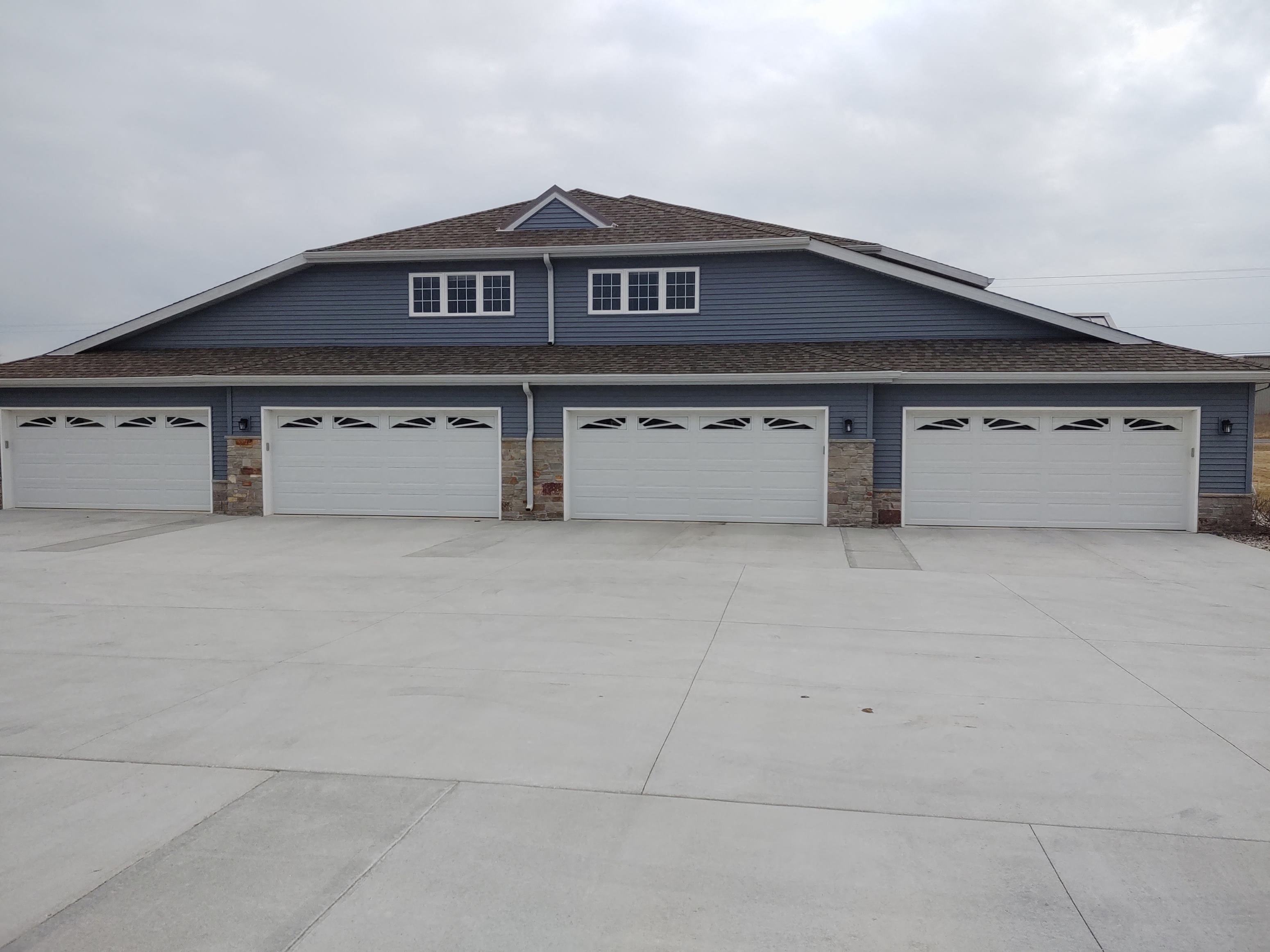 the front of a garage with three white garage doors
