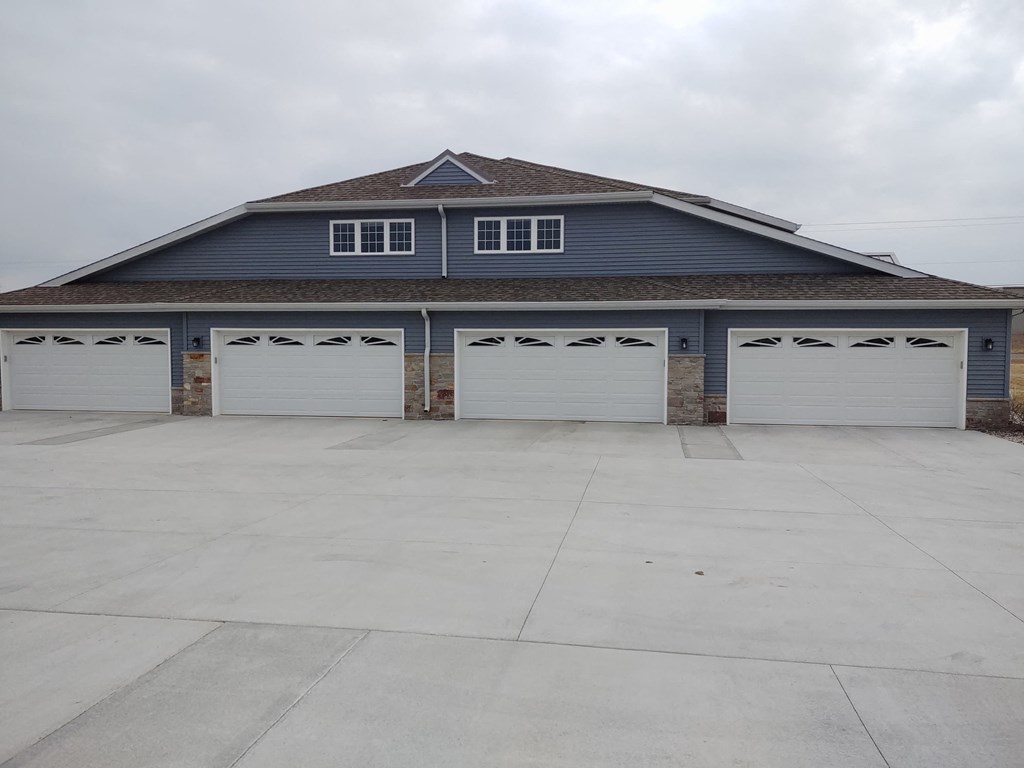 the front of a garage with three white garage doors
