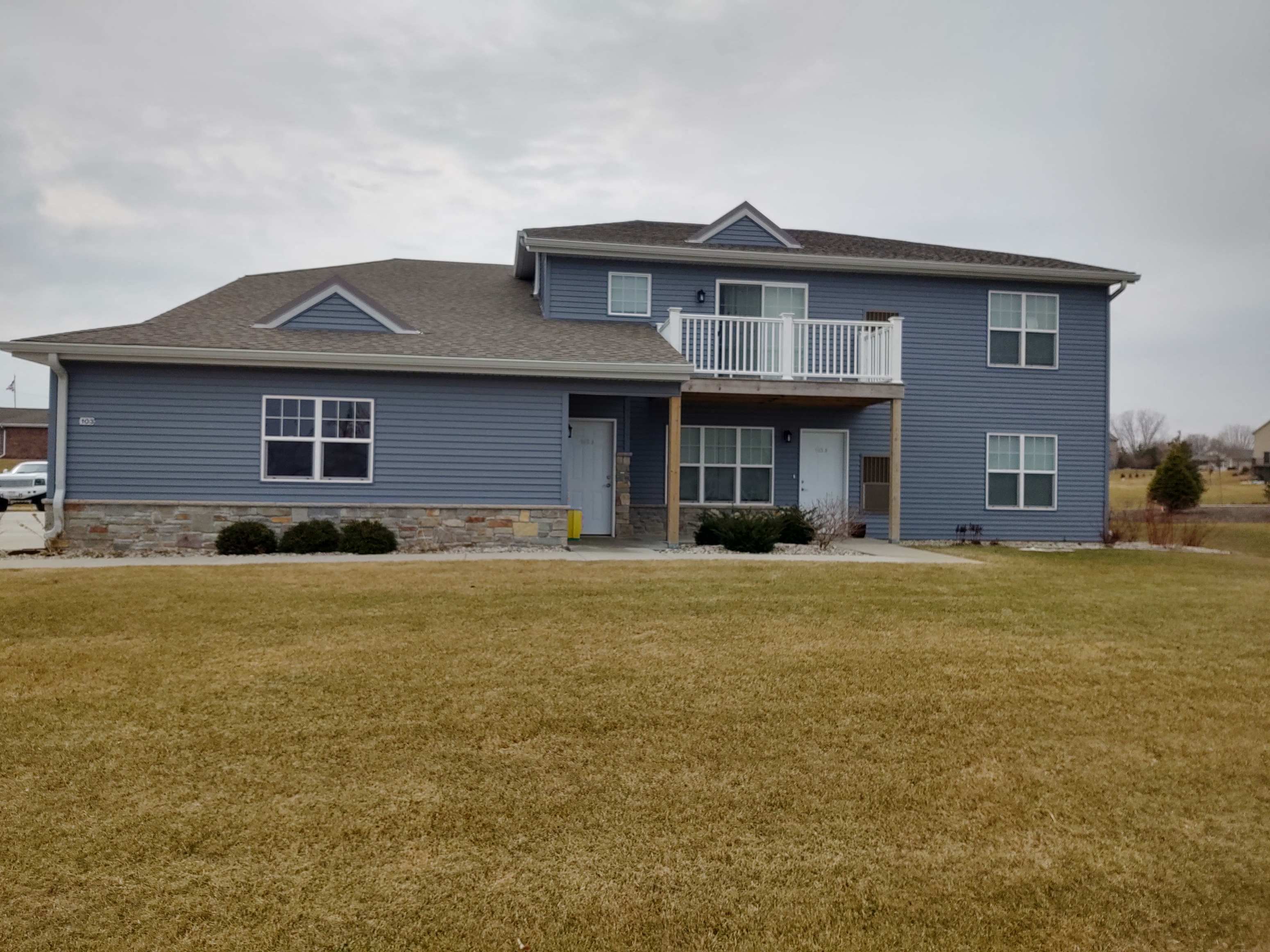 a blue house with a yard in front of it