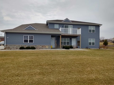 a blue house with a yard in front of it