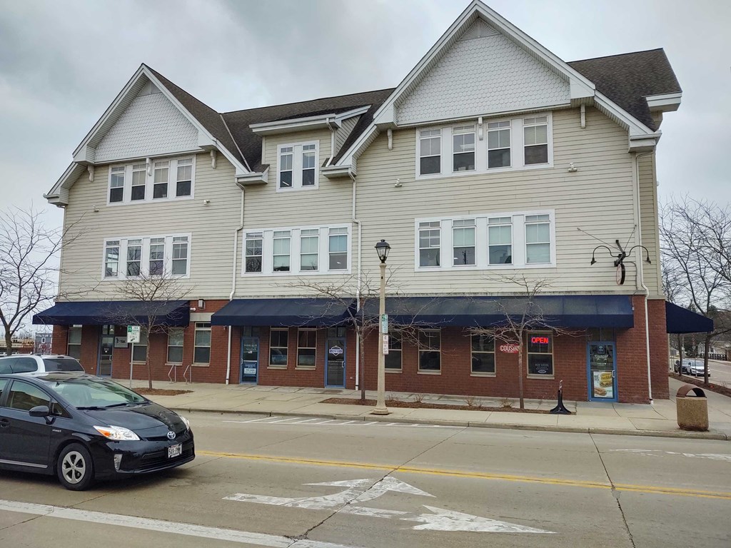 a house on the corner of a street with a car