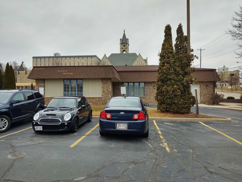 a parking lot with three cars in front of a building